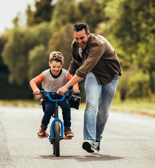 Father helping son ride a bike
